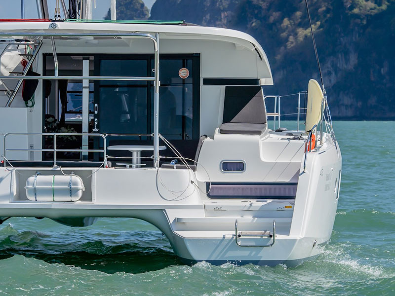 Boat from rear while cruising in the sea. People stnading inside
